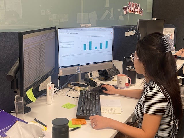 Photo of a researcher looking at spreadsheets and graphs on computer screens.