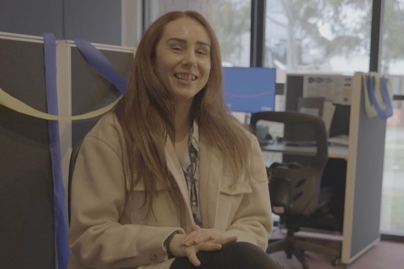 Photo of Ms Adamovic sitting down in the Lifeline volunteer office.
